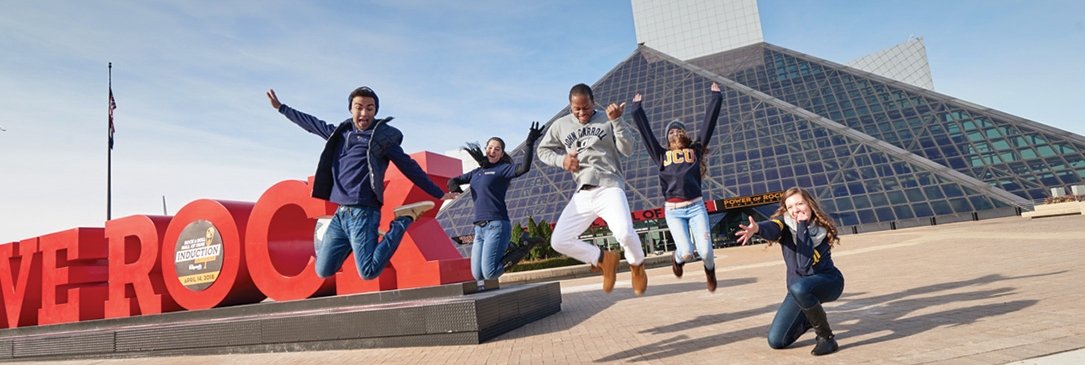 «Ӱҵ students jumping in front of 'WE ROCK" sign